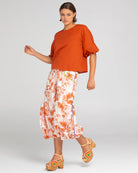 A woman modelling the Ava Puffed Sleeves Top in Mecca Orange by Boom Shankar