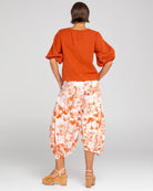 A woman modelling the Ava Puffed Sleeves Top in Mecca Orange by Boom Shankar