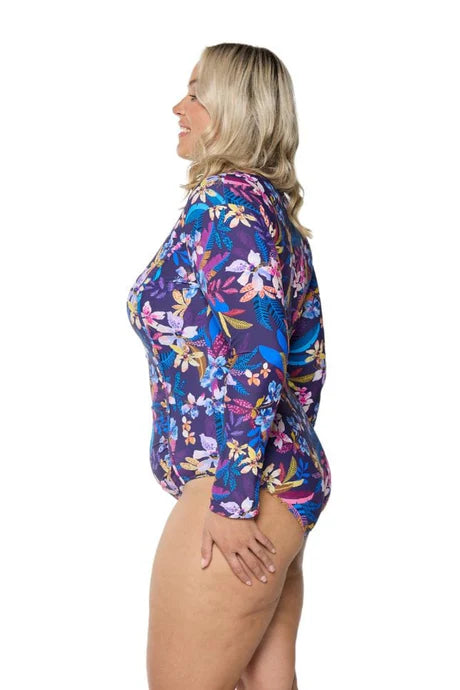 A tropical floral Majorca long sleeve one-piece swimsuit with a zippered neckline, flattering curve-enhancing fit, and rich inky blue base.