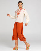 A woman modelling Boom Shankar Guru Pants in Mecca Orange