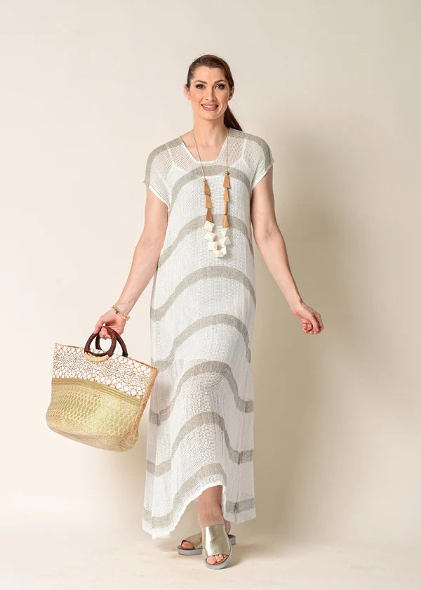 The Melania Linen Dress, a sleeveless, breathable linen piece with side slits, styled minimally for a light and airy summer look.