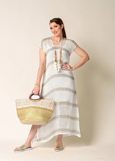 The Melania Linen Dress, a sleeveless, breathable linen piece with side slits, styled minimally for a light and airy summer look.