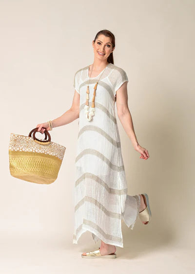 The Melania Linen Dress, a sleeveless, breathable linen piece with side slits, styled minimally for a light and airy summer look.