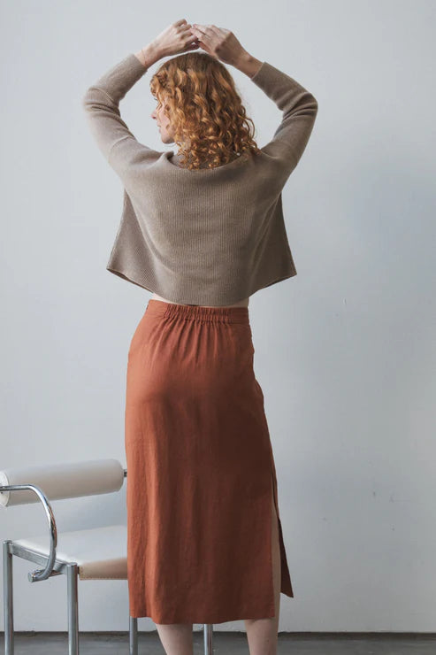 Nadi Linen Skirt in Cajun – A stylish, straight-cut linen skirt in a warm Cajun hue. Features oversized front pockets, side splits for ease of movement, and an elasticated back waistband for a comfortable, flattering fit.