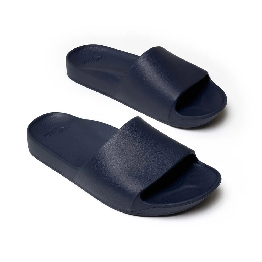 A pair of navy blue arch support slides with a contoured footbed, designed for comfort and stability. The slides feature a wide strap across the top and a cushioned sole for all-day wear.