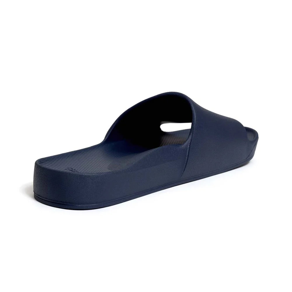 A pair of navy blue arch support slides with a contoured footbed, designed for comfort and stability. The slides feature a wide strap across the top and a cushioned sole for all-day wear.