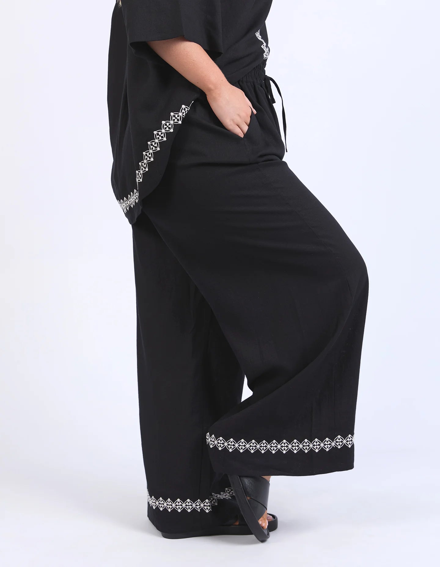 Black linen-viscose pants with an elastic waistband and embroidered hem, offering a relaxed and stylish fit.