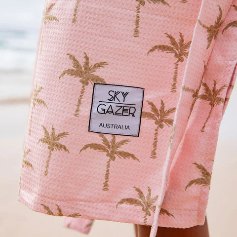 The Palm Surf Poncho is a sand-free, super-absorbent, quick-drying hooded towel. Lightweight, antibacterial, and soft, with a pocket and optional waist tie.