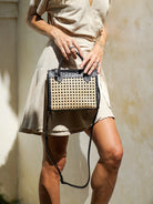 Prague Clutch in black and tan featuring natural rattan weaving with genuine leather accents in a sleek summer-ready design.