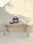 Prague Clutch in black and tan featuring natural rattan weaving with genuine leather accents in a sleek summer-ready design.