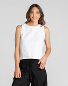 White Rosa Linen Top with a boat neckline, sleeveless design, scooped back hem, and shell button details.