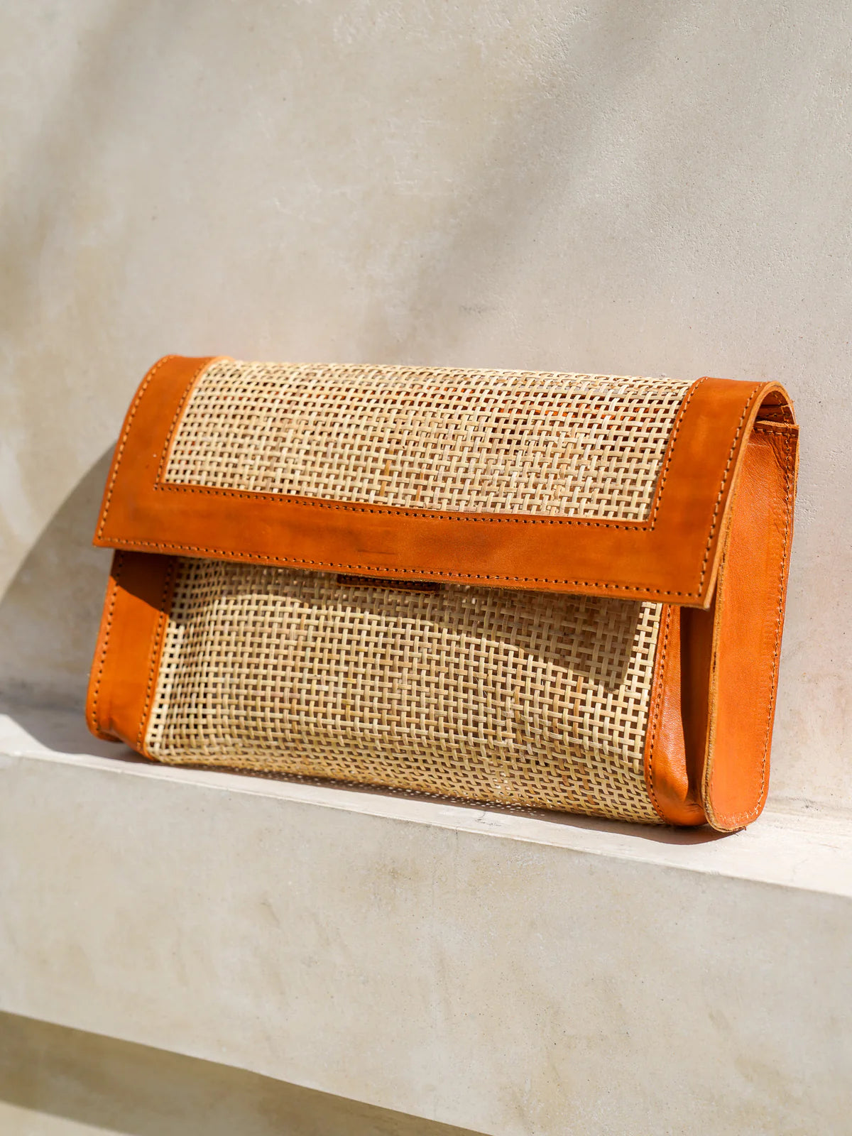 Seoul Clutch in white featuring Indonesian rattan cane webbing with leather trim in a sleek, elegant clutch silhouette.