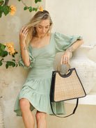 Singapore Bag in black featuring natural rattan weaving with genuine leather detailing in a structured summer handbag design.