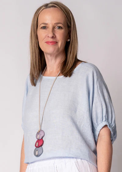 Solene Linen Top in baby blue with a relaxed fit, round neckline, elasticated mid-length sleeves and a lightweight linen finish.