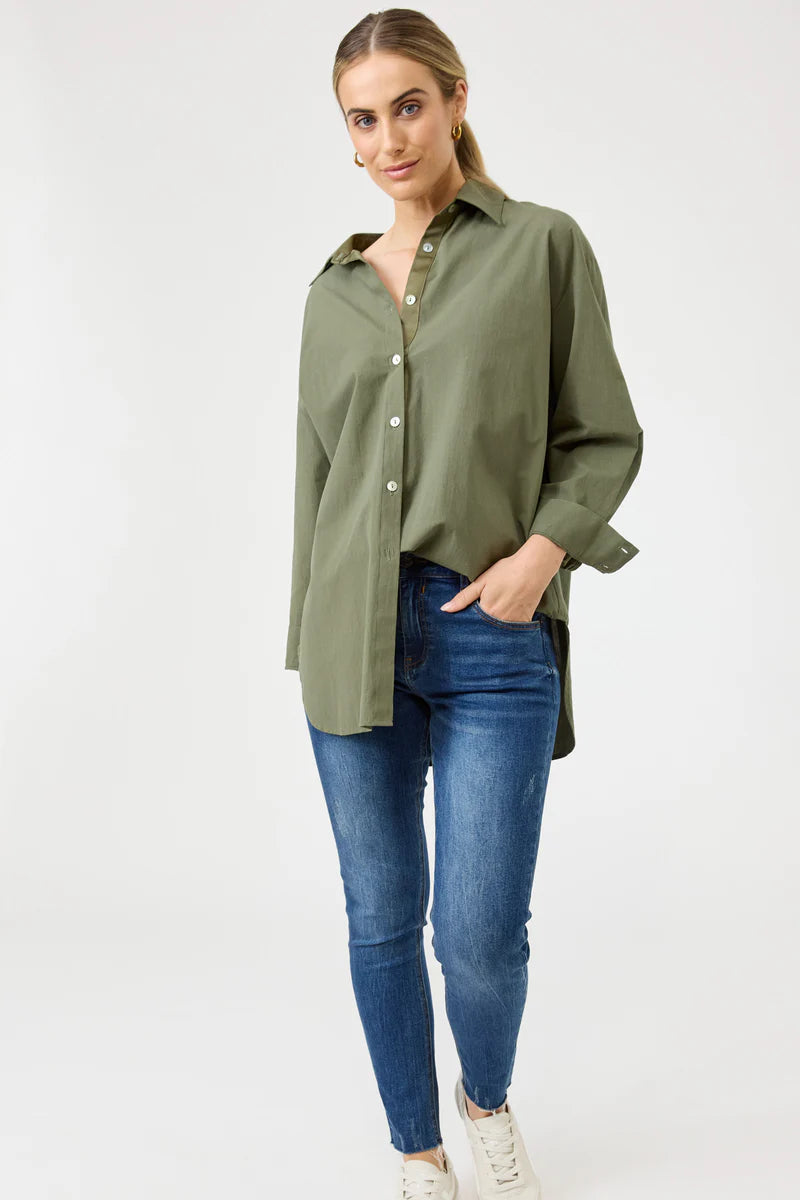 A khaki oversized button-down shirt made from soft cotton, featuring a relaxed fit, classic collar, and long sleeves, styled effortlessly for a casual yet polished look.