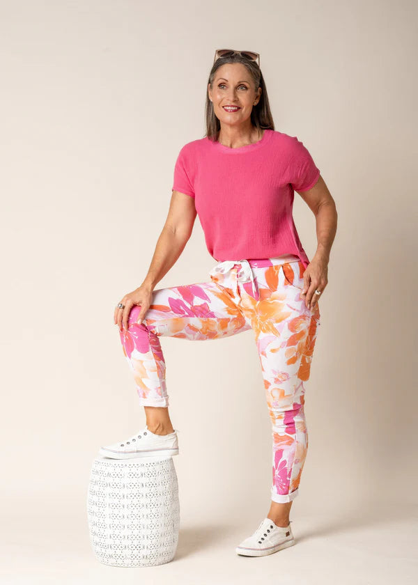 A woman modelling the Brittny Elastic Waist Pants in Sunset Orange by Imagine Fashion