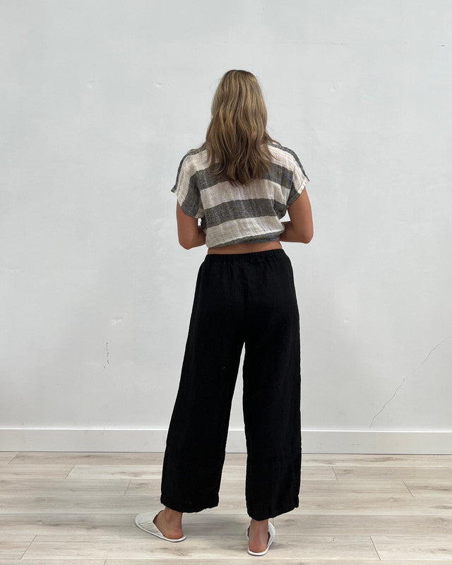 Relaxed black linen pants with a soft drape and comfortable fit, styled in a timeless, minimalist look for everyday wear.