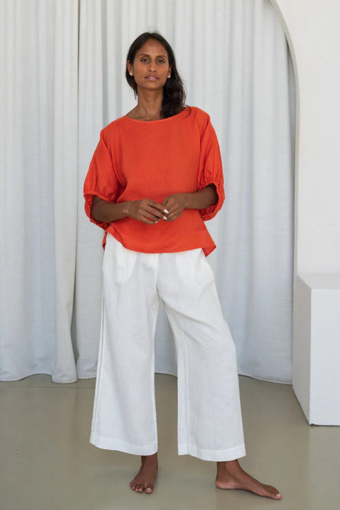 The Lily Pilly Tina Top in vibrant orange spritz is designed with a relaxed silhouette, lightweight feel, and natural linen textured weave.
