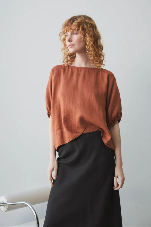 Tina Linen Top in Cajun – A breathable, lightweight linen top in a warm, earthy Cajun hue. Designed with a relaxed fit, short sleeves, and a button-down front for effortless, everyday styling.