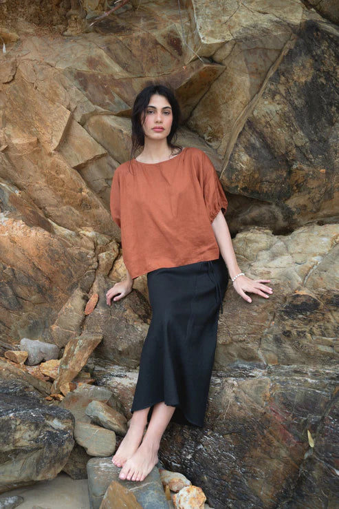 Tina Linen Top in Cajun – A breathable, lightweight linen top in a warm, earthy Cajun hue. Designed with a relaxed fit, short sleeves, and a button-down front for effortless, everyday styling.