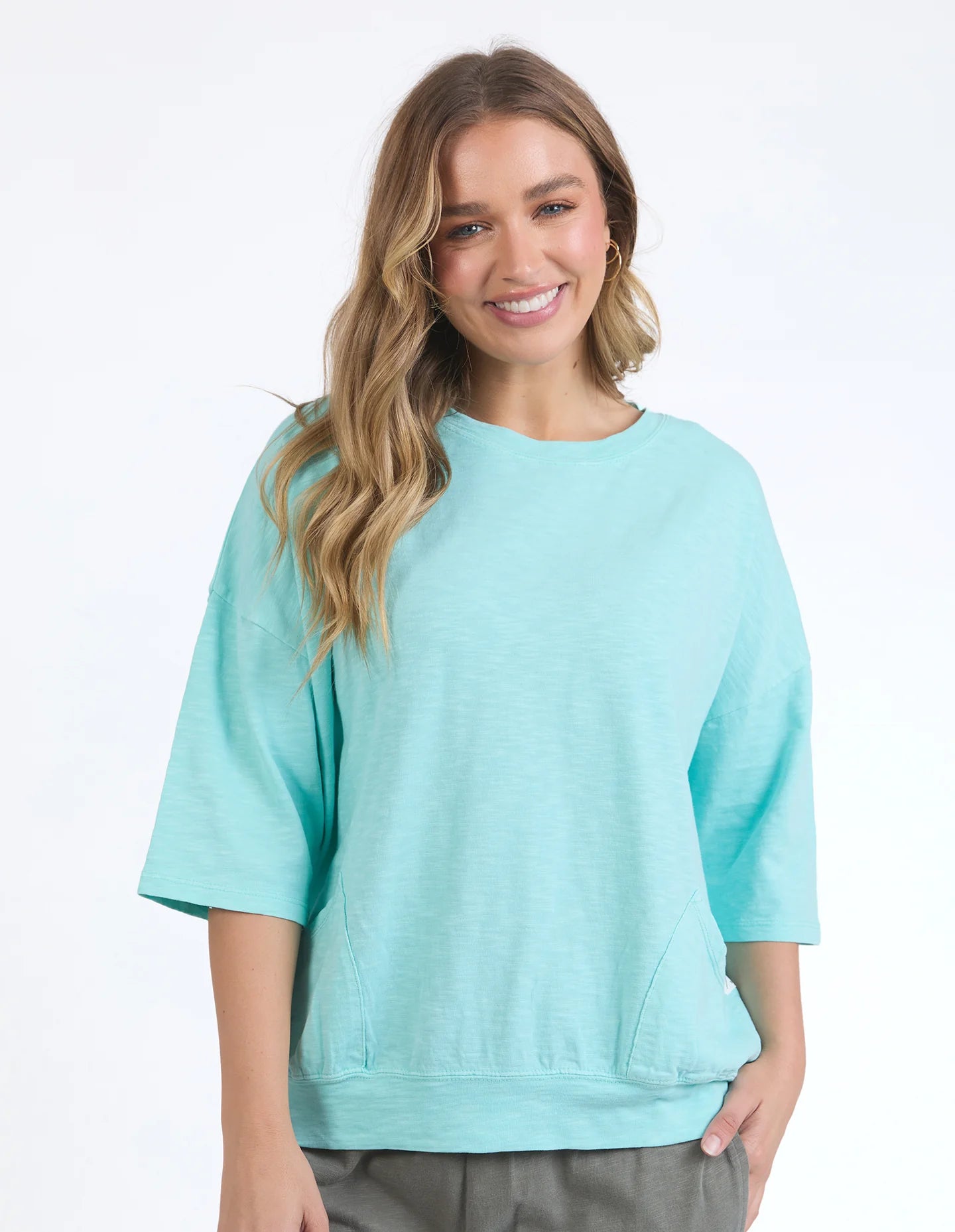 Mazie Sweat in tonic blue with a relaxed oversized fit, 3/4 length sleeves, front pockets, and lightweight 100% cotton fabric.