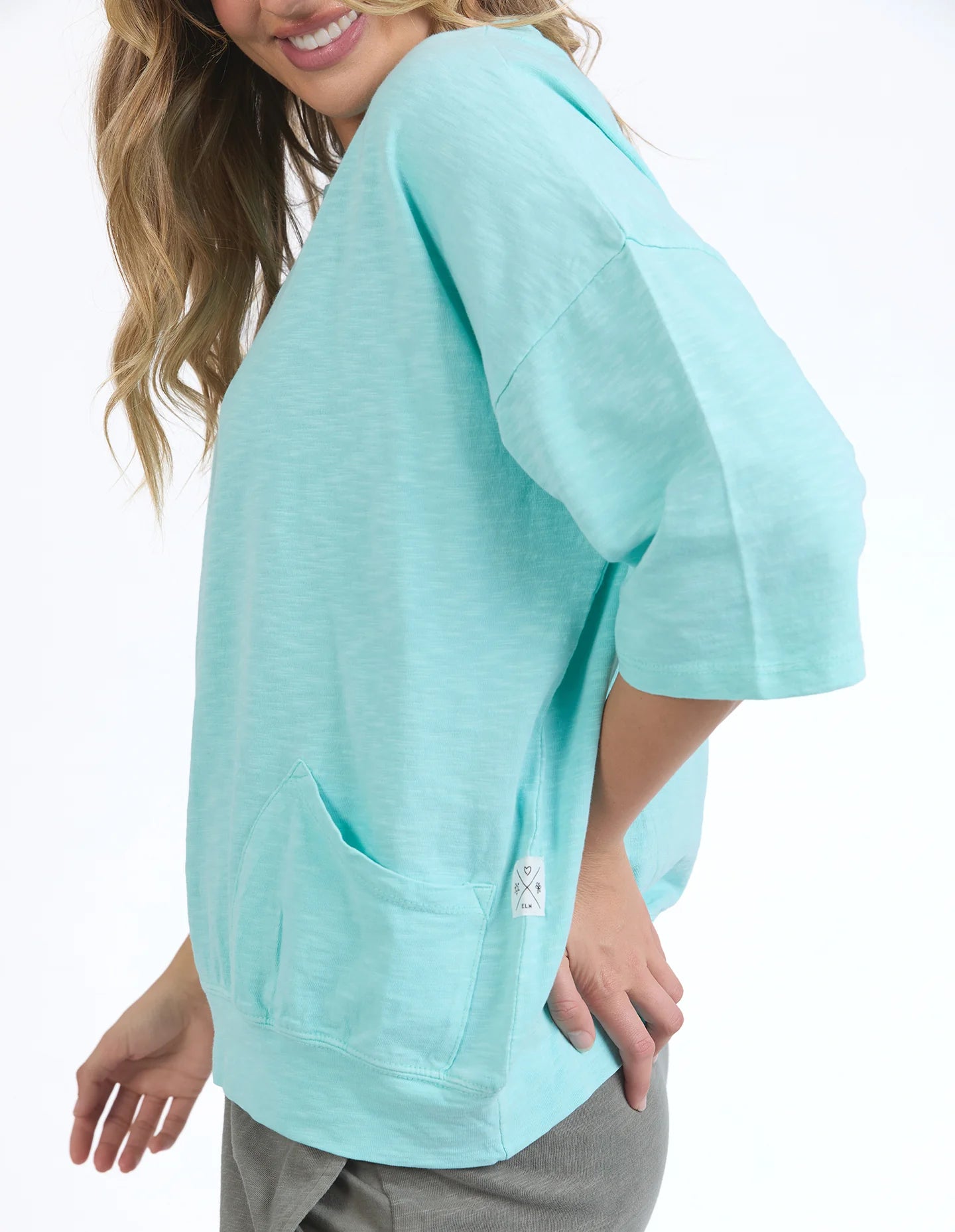 Mazie Sweat in tonic blue with a relaxed oversized fit, 3/4 length sleeves, front pockets, and lightweight 100% cotton fabric.