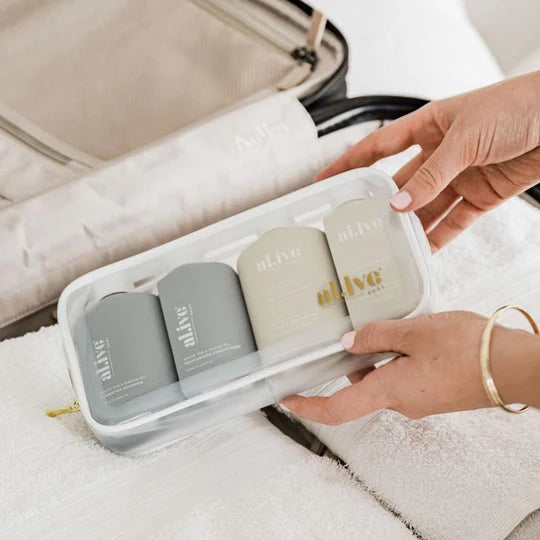al.ive body Travel Essentials Set featuring White Tea & Argan Shampoo and Conditioner and Sea Cotton & Coconut Hand & Body Wash and Lotion in a sleek travel case.
