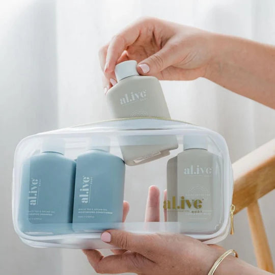 al.ive body Travel Essentials Set featuring White Tea & Argan Shampoo and Conditioner and Sea Cotton & Coconut Hand & Body Wash and Lotion in a sleek travel case.
