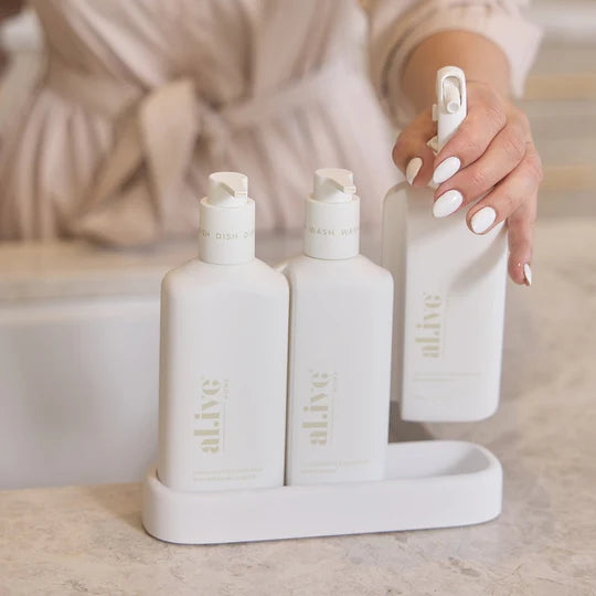 The Alive Kitchen Trio Set in Lemon Myrtle & Honeydew, featuring Dishwashing Liquid, Bench Spray, and Hand Wash, arranged neatly in a sleek, custom tray. The set is displayed against a clean, bright countertop, showcasing the crisp white bottles and elegant design, with soft green and yellow hues evoking the fresh, citrusy scent of lemon myrtle and honeydew.