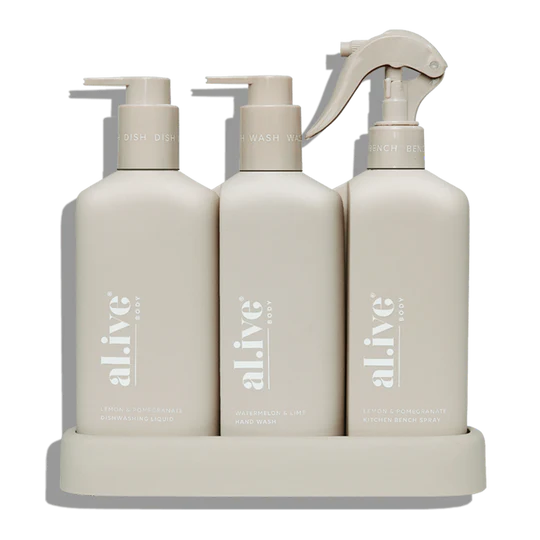 The Alive Kitchen Trio Set, featuring Dishwashing Liquid and Bench Spray in Lemon & Pomegranate scent, and Hand Wash in Watermelon & Lime scent, all neatly arranged in a sleek, custom tray. The white bottles with vibrant, fresh-colored labels are displayed on a clean countertop, exuding a refreshing and vibrant aesthetic with fruity, citrus-inspired fragrances.