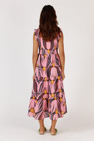 A feminine midi dress in a soft textured Tulip print, made from a cotton-nylon blend. The design features a round neckline with a delicate frill, sleeveless armholes with matching frill trim, and a shirred bodice that contours the figure. A flowing A-line skirt falls to mid-calf, complemented by functional pockets for added ease. The dress offers a relaxed, elegant fit suitable for a variety of occasions