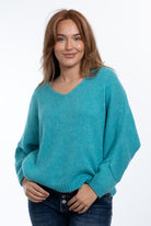 A woman wearing a Turquoise Daria jumper by The Italian Cartel