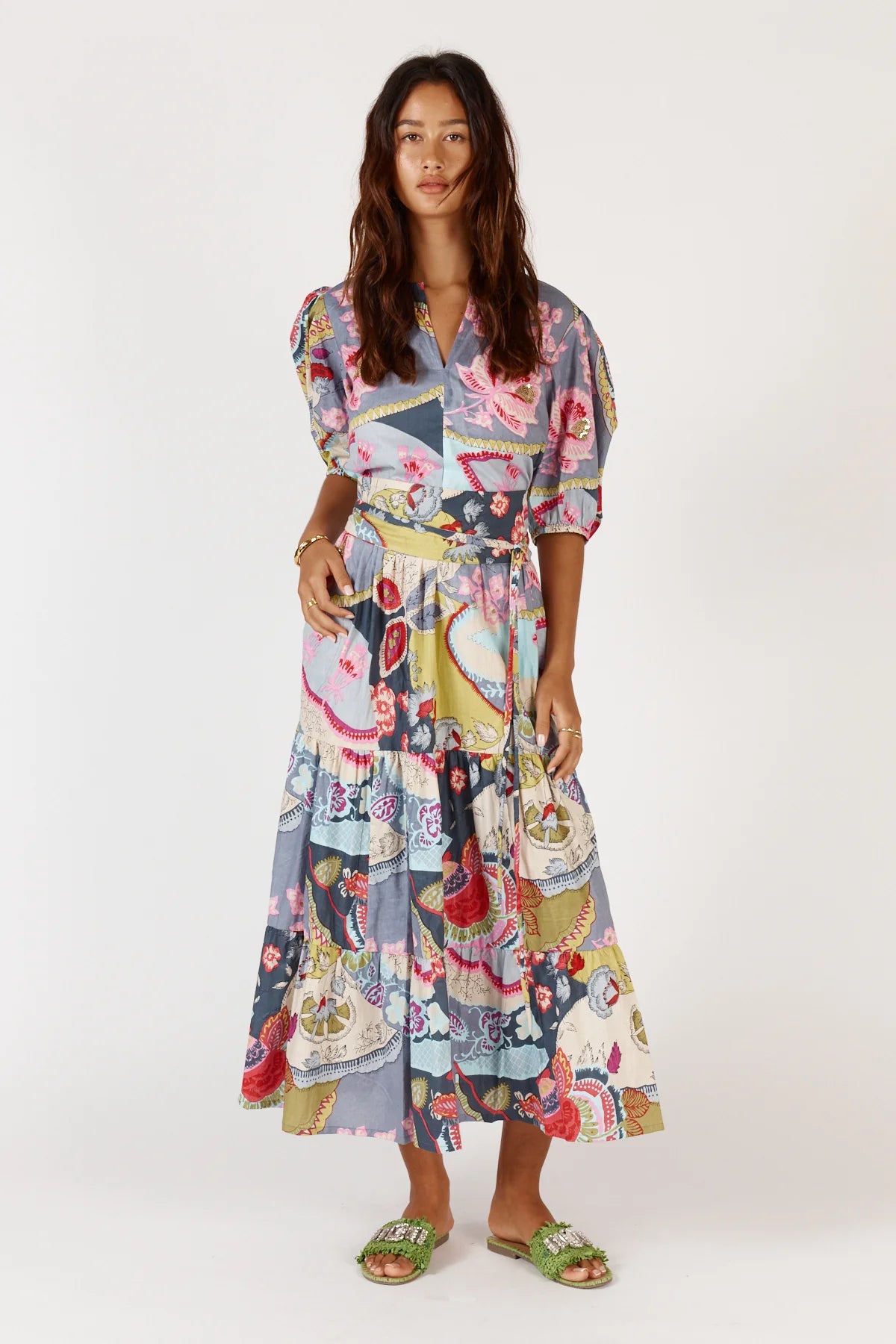 A floral print Udita Maxi Dress featuring puffed sleeves, a round neckline with a split, a self-fabric cummerbund belt, and side seam pockets.