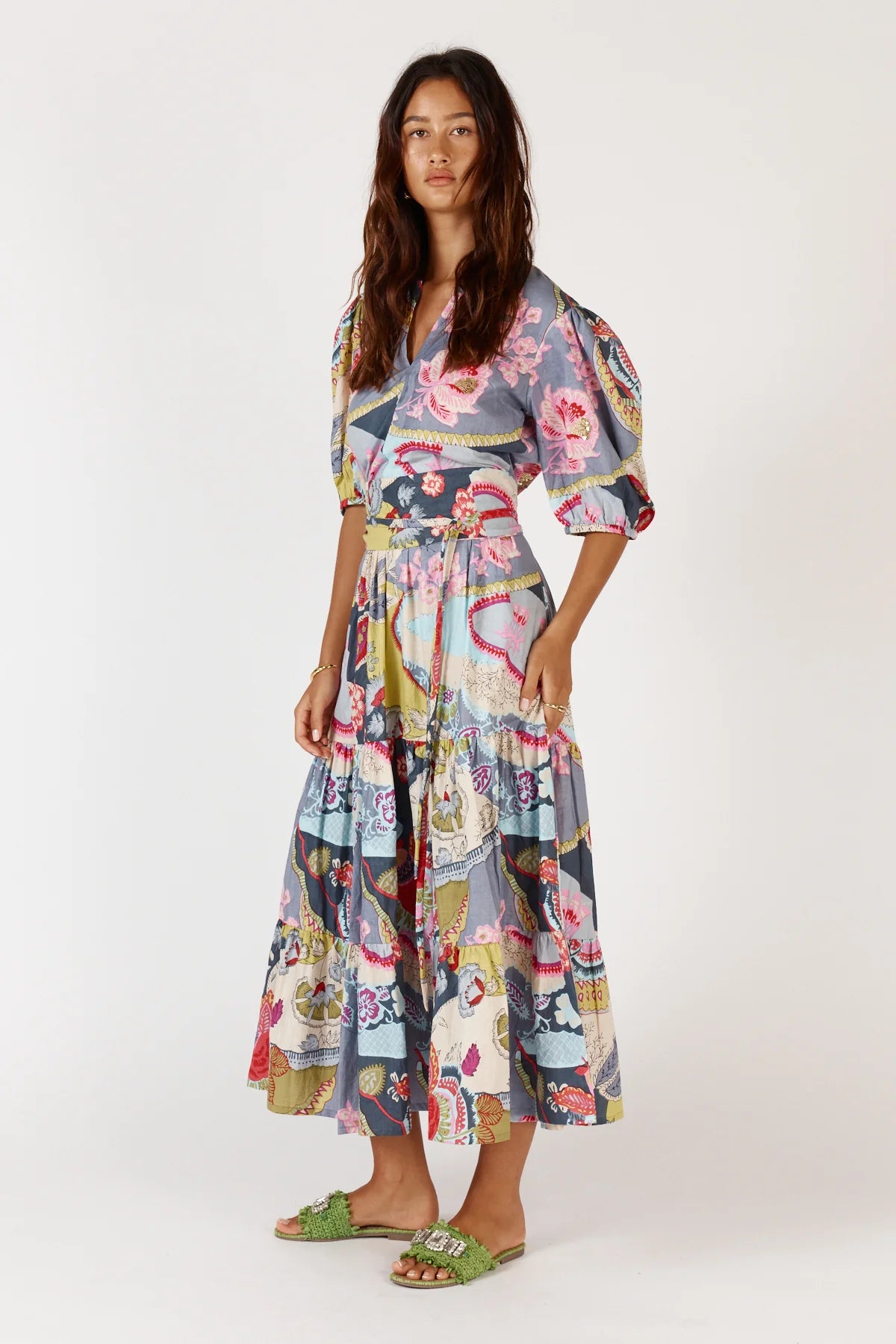 A floral print Udita Maxi Dress featuring puffed sleeves, a round neckline with a split, a self-fabric cummerbund belt, and side seam pockets.