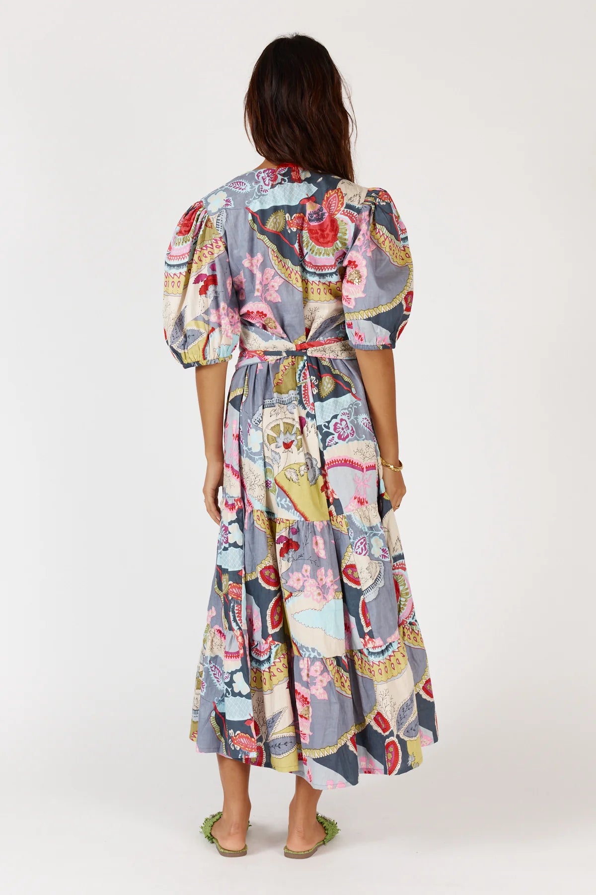 A floral print Udita Maxi Dress featuring puffed sleeves, a round neckline with a split, a self-fabric cummerbund belt, and side seam pockets.