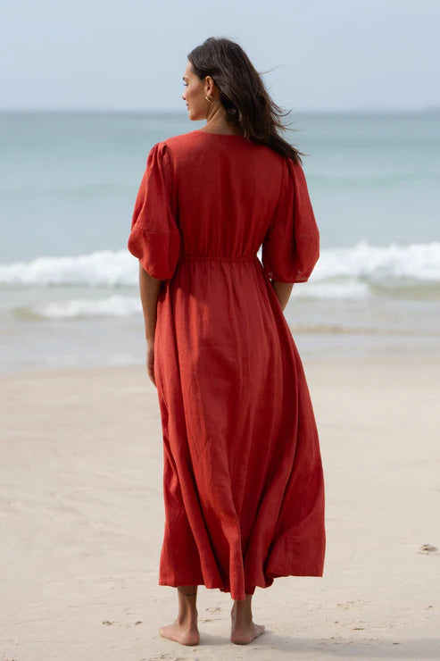 Vida Linen Dress in Hibiscus – A flowy midi-to-maxi linen dress in a vibrant hibiscus hue. Features an adjustable front-tie waistline, oversized bell sleeves, side pockets, and premium French seams for a refined finish.